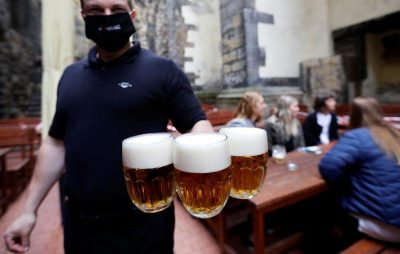 A bartender carries beers at an outdoor seating section of a pub, as the Czech government lifted more restrictions allowing restaurants with outdoor areas to re-open amid the coronavirus disease. Reuters
