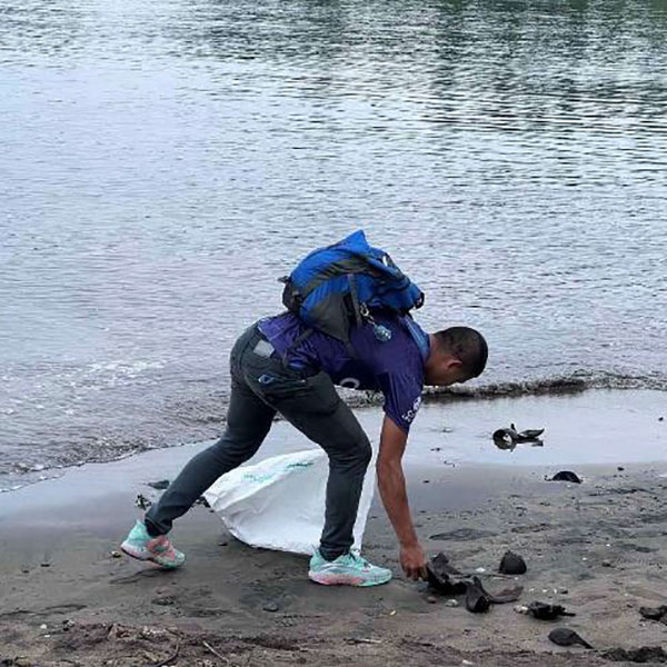 A volunteer from SM City Legazpi cleans up the coast of Legazpi Boulevard.